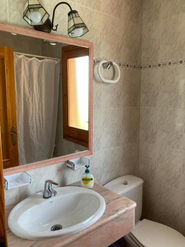 a bathroom with a sink and a mirror and a toilet at Beautiful Villa & Swimming Pool in Cala Blanca in Cala Blanca