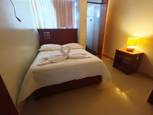 ein Schlafzimmer mit einem Bett mit zwei Handtüchern darauf in der Unterkunft hospedaje encantada in Cajamarca
