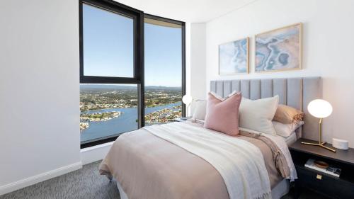 um quarto com uma cama grande e janelas grandes em Surfers Paradise New Beachfront 2&3 BED APT em Gold Coast