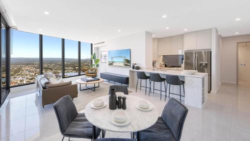 a kitchen and living room with a table and chairs at Surfers Paradise New Beachfront 2&3 BED APT in Gold Coast