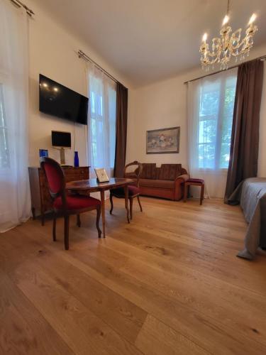 a living room with a table and a couch at Villa Musik - Historical apartments in Baden in Baden