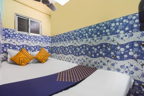 a bedroom with a bed with a blue and white wall at OYO Hotel Sonar Bangla Lodge in Kolkata