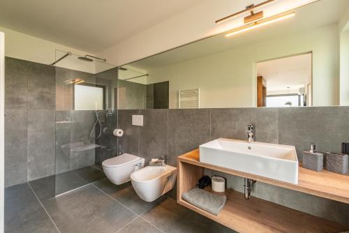 uma casa de banho com um lavatório e um WC em Apfelhof em Termeno