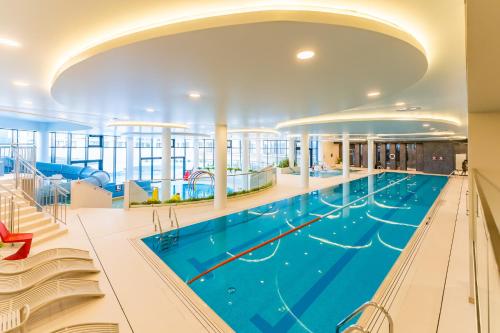 a large swimming pool in a large building at FARO Apartamenty Polanki Aqua SPA Deluxe 4 baseny w cenie, Pools inklusive in Kołobrzeg