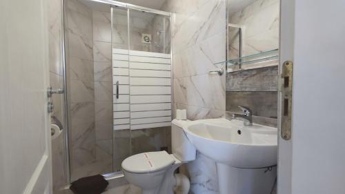y baño con aseo, lavabo y ducha. en Family Hotel Milev en Sveti Vlas