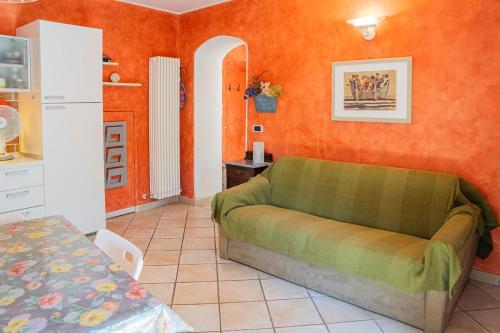 ein Wohnzimmer mit Sofa und orangefarbenen Wänden in der Unterkunft 071 - CASA GIOIELLO, GIARDINO, 10 minuti MARE SPIAGGIE in Sestri Levante