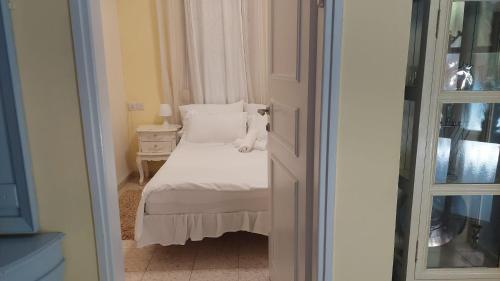 a small bedroom with a white bed and a window at וילה בת גליל יסוד המעלה in Yesod Hamaala