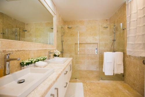 a bathroom with two sinks and a shower at Tranquil Lakefront 5-Bedroom Villa with Cook, Maid, Golf Cart, and Beach Access in Punta Cana in Punta Cana