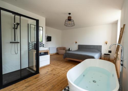 uma casa de banho com banheira e um quarto em Gîte du Manoir de Berville em Saint-Pierre-sur-Dives