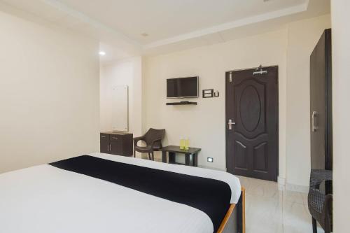 a bedroom with a bed and a door with a tv at Hotel Aditya Grand in Guntūr