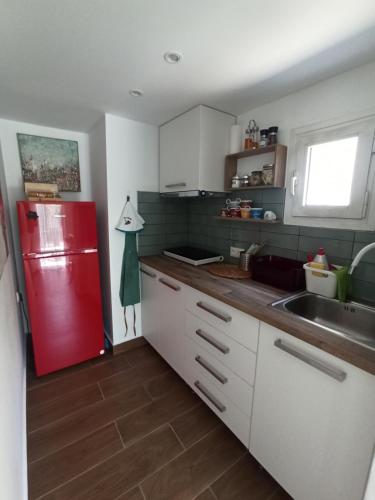 a kitchen with a red refrigerator and a sink at Cosy loft in Platamonas