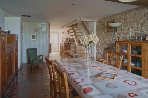 une salle à manger avec une grande table et des chaises ainsi qu'une cuisine dans l'établissement Rouge-cœur, à Montaigu