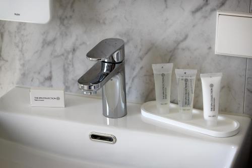 a bathroom sink with a faucet and toothbrushes on it at Nova Apartments Amsterdam in Amsterdam