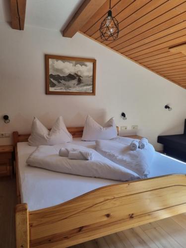 a bedroom with a large bed with white sheets at Haus Marinus in Jerzens