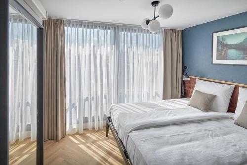 a bedroom with a bed and a large window at Nova Apartments Amsterdam in Amsterdam