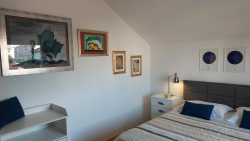 Mislav Apartment في تروغير: غرفة نوم بسرير وصور على الحائط