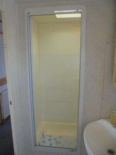 a glass shower in a bathroom with a sink at Seaview: The Crown:- 6 Berth, Central heated, Enclosed Veranda in Ingoldmells