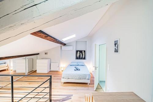 a white bedroom with a bed and a staircase at Appartement Bellecour - Emplacement prime in Lyon