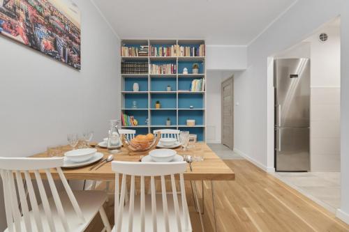uma sala de jantar com uma mesa e um frigorífico em Apartment Jesionowa with FREE GARAGE Wrocław by Renters em Breslávia