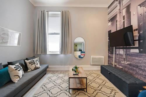 ein Wohnzimmer mit einem Sofa und einem TV in der Unterkunft Host & Stay - Halifax House Apt II in Liverpool