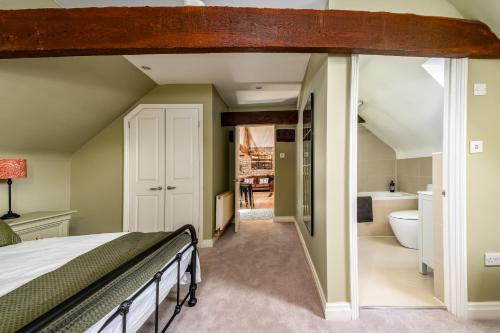 a bedroom with a bed and a bathroom at Luxury town centre loft apartment in converted Granary in Stamford