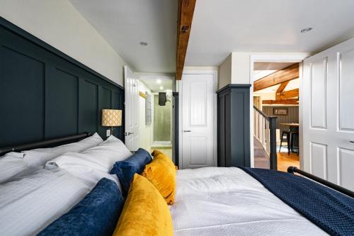 a bedroom with a large bed with a black headboard at Luxury town centre loft apartment in converted Granary in Stamford