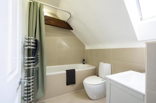 a bathroom with a toilet and a bath tub at Luxury town centre loft apartment in converted Granary in Stamford