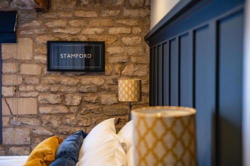 a living room with a stone wall and a couch at Luxury town centre loft apartment in converted Granary in Stamford