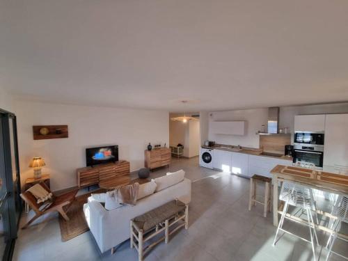 uma sala de estar com um sofá e uma cozinha em D34 - T3-Les Hauts du Port-parking-clim-wifi-50m du port em Bonifacio
