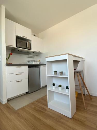 uma cozinha com armários brancos e um balcão com plantas em Saint-Maur Créteil - Proche Paris centre et Disney em Saint-Maur-des-Fossés