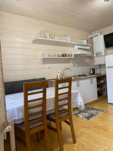 a kitchen with a table and two chairs in a room at Карпатська Модрина in Kosiv