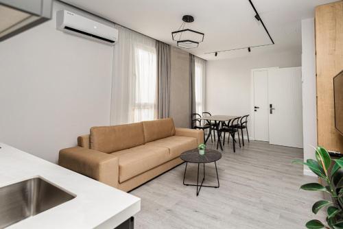 - un salon avec un canapé et une table dans l'établissement Marina Luxury Apartments Durrës, à Durrës