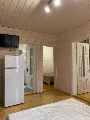 a kitchen with a white refrigerator in a room at Карпатська Модрина in Kosiv