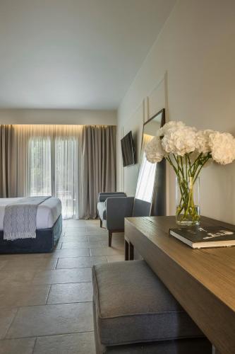 a hotel room with a bed and a table with flowers at Thalassa Boutique Hotel - Adults Only in Lassi