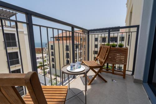 a balcony with two chairs and a table at HiGuests - Stylish Waterfront Retreat With Balcony in La Mer in Dubai