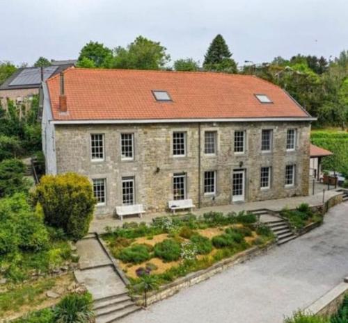 ein großes Backsteingebäude mit einem Garten davor in der Unterkunft Gîte La Forestière in Walcourt