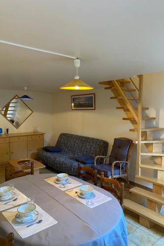- un salon avec une table, un canapé et des escaliers dans l'établissement Carnac - Maison - Environnement nature et spacieux - 4-5 km des plages, à Carnac