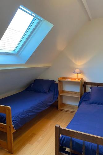 deux lits dans une chambre mansardée avec une fenêtre dans l'établissement Carnac - Maison - Environnement nature et spacieux - 4-5 km des plages, à Carnac