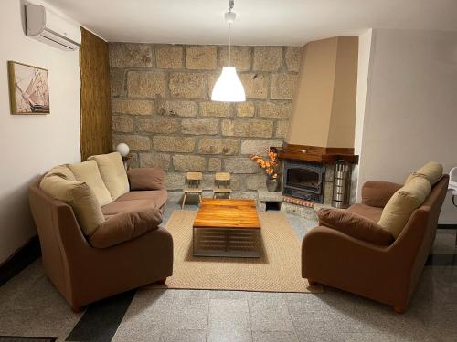 a living room with two chairs and a coffee table at Estrela do Geres in Geres