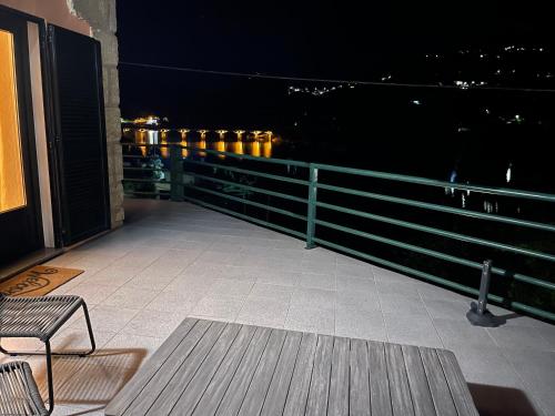 a balcony with a bench and a railing at night at Estrela do Geres in Geres