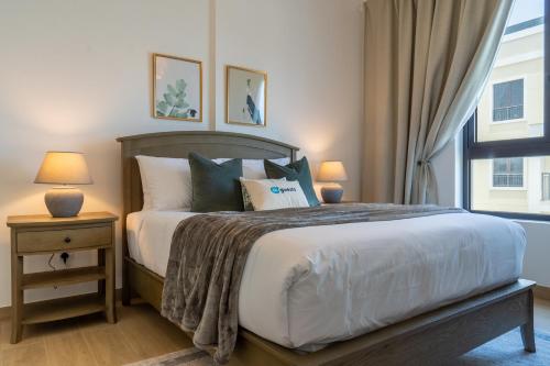 een slaapkamer met een groot bed en een raam bij HiGuests - Stylish Waterfront Retreat With Balcony in La Mer in Dubai