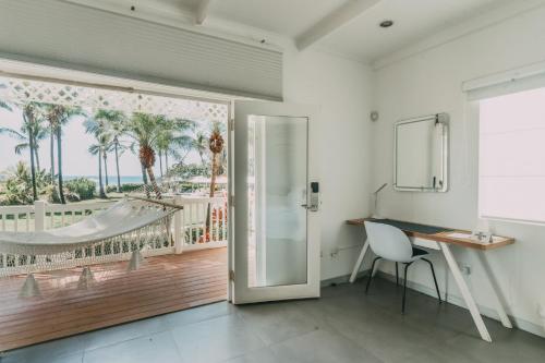 Azul Hotel & Retreat في Playa Azul: غرفة بها مكتب وباب زجاجي منزلق