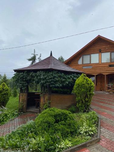 a house with a pavilion in front of it at Карпатська Модрина in Kosiv
