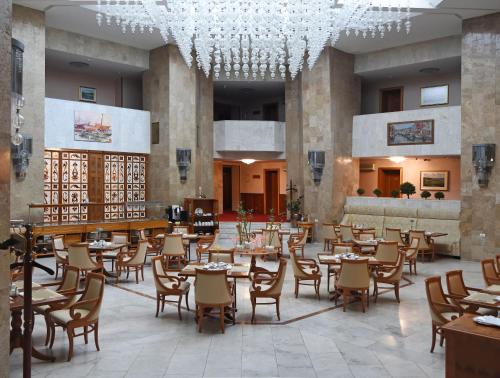 um restaurante com mesas e cadeiras e um lustre em Natsionalny Hotel em Kiev