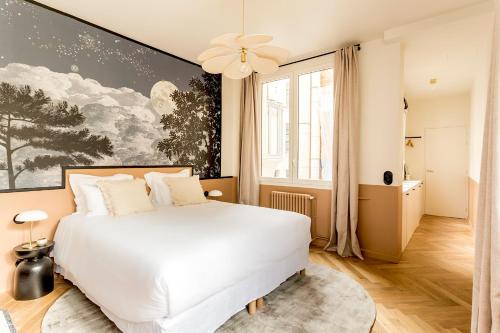 a bedroom with a white bed and a large painting on the wall at Bourse Feydeau in Paris