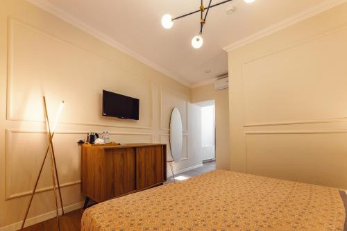 a bedroom with a bed and a tv on the wall at Boutique Hotel Manufactura in Tbilisi City