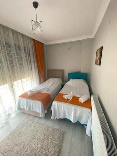 a bedroom with two beds and a window at Villa Keyif in Seferihisar