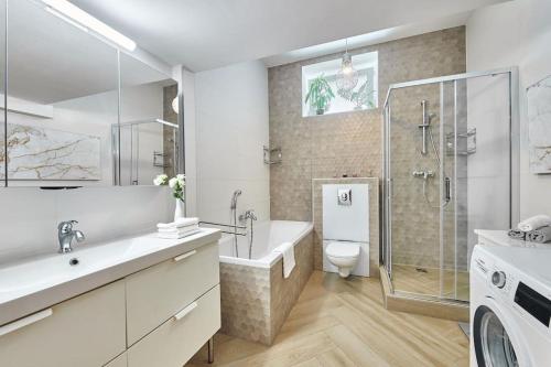 a bathroom with a tub and a shower and a toilet at Cozy loft with terrace in the city center in Staré Mesto