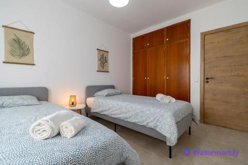 カルヴォエイロにあるEnjoy Carvoeiroのベッドルーム1室(ベッド2台、クローゼット付)