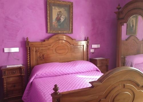 サンタニェッロにあるCasa Tètta two styles living togetherの紫の壁のベッドルーム1室、ピンクのシーツが備わるベッド2台が備わります。